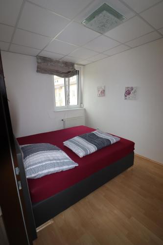 a bedroom with a red bed in a room at Ferienwohnung GGM in Judenburg