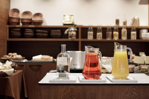 two bottles and glasses on a counter with drinks at Hotel Bergland in Cadipietra