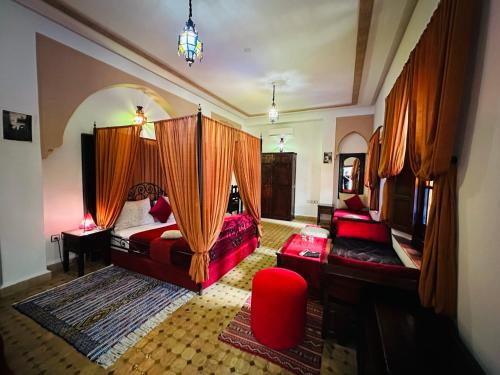 a bedroom with a bed and a couch and a chair at Riad Ahlam in Fès