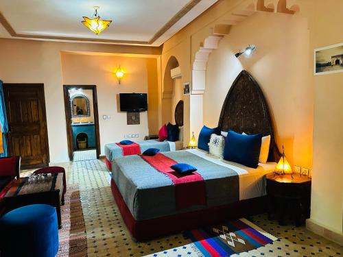 een hotelkamer met 2 bedden en een televisie bij Riad Ahlam in Fès