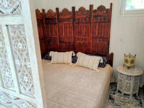 um quarto com uma cama e uma cabeceira em madeira em Oriental Tiny House mit Sauna em Wendisch Rietz