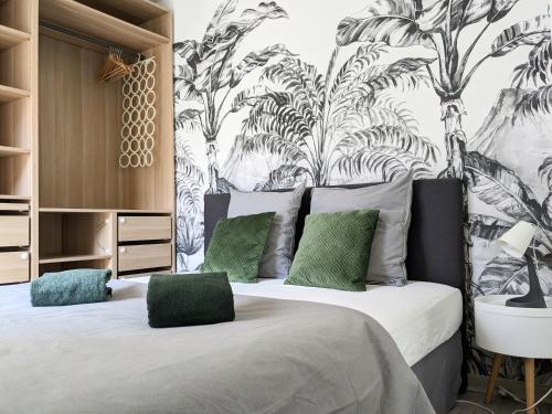um quarto com uma cama grande e almofadas verdes em La Terrasse du tramway, Parking, 30min de Paris em Bezons