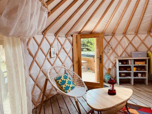 a room with a table and chairs in a yurt at Yourte et son bain nordique in Fréchet-Aure