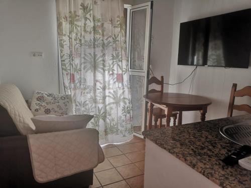 Sol y playa في كونيل دي لا فرونتيرا: مطبخ وغرفة معيشة مع أريكة وطاولة