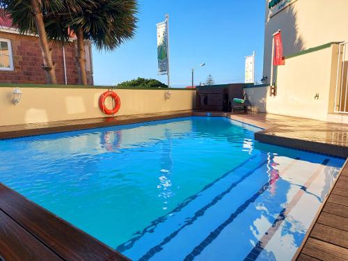 a swimming pool with blue water on a building at First Group Perna Perna Mossel Bay in Mossel Bay