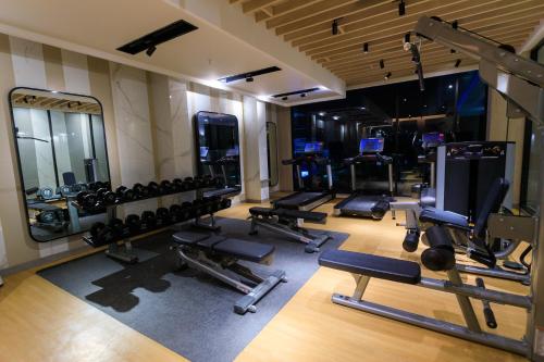 a gym with a bunch of equipment in a room at Calma 31 Apartment in Makassar