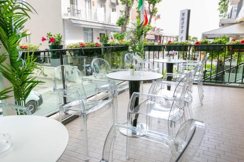 una fila di tavoli e sedie su un balcone fiorito di Hotel Nuovo Giardino a Rimini