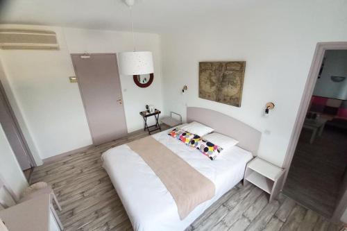 um quarto com uma grande cama branca com almofadas em Les Grizzlies-le Mauzac em Limoux
