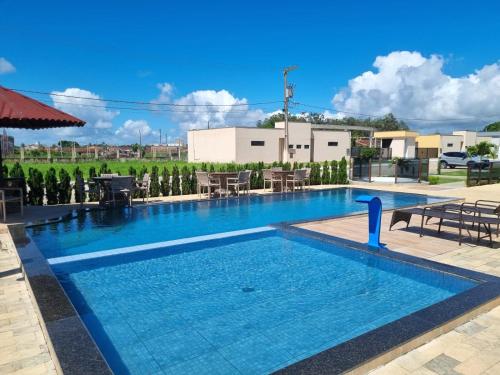 una piscina en un hotel con mesas y sillas en Lar das Cerejeiras en Bananeiras