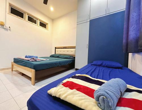 sypialnia z 2 łóżkami i niebieską ścianą w obiekcie Stay N rest sweet home 185 w mieście Seremban