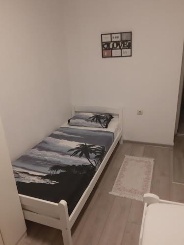 uma cama num quarto com uma parede branca em Apartman Sema em Donji Štoj
