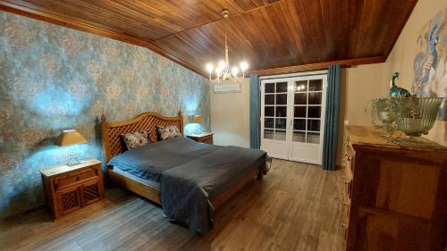 een slaapkamer met een bed en een kroonluchter bij Quinta RoSa - Almeirim in Almeirim