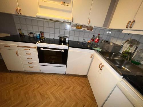 a kitchen with a sink and a stove top oven at Nice room with balcony in Gothenburg