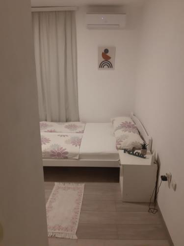 um pequeno quarto com uma cama e uma janela em Apartman Sema em Donji Štoj