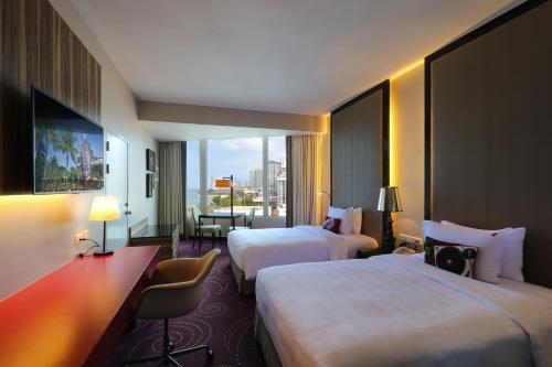 a hotel room with two beds and a large window at Hard Rock Hotel Pattaya in Pattaya Central