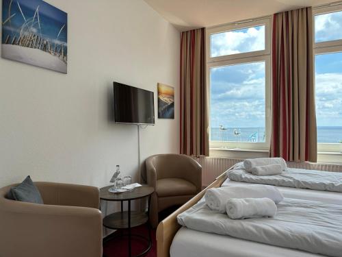 una camera d'albergo con due letti e una finestra di Zeitlos Hotel Garni a Scharbeutz