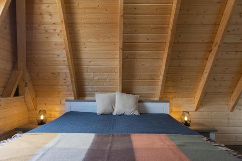 a bed in a wooden room with two pillows at MP39 - Strandvogt 2 Komfort in Dorum Neufeld