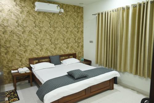 ein Schlafzimmer mit einem großen Bett und einer Wand mit einem Vorhang in der Unterkunft Shree haveli homestay in Ujjain