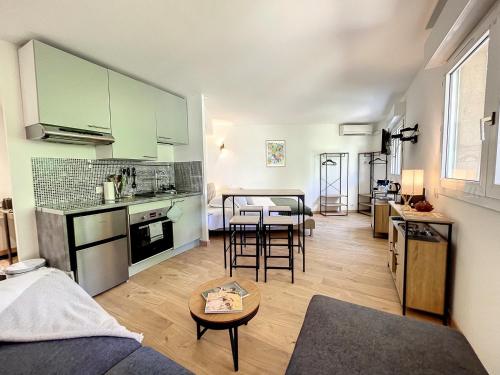 Il comprend une cuisine et un salon avec une table. dans l'établissement Appartement cosy au centre de Cannes, à Cannes