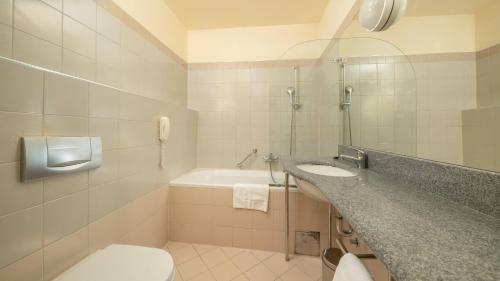 a bathroom with a toilet and a sink and a tub at Hotel Plitvice in Plitvička Jezera