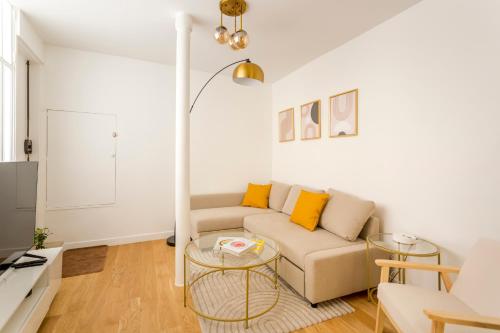 un salon avec un canapé et une table dans l'établissement 1 BDR Bourse -Opera with AC, à Paris