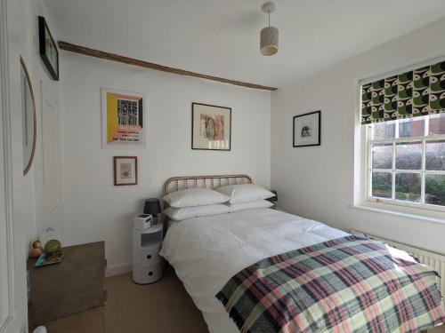 a white bedroom with a bed and a window at Arts House centre of Harwich Harbour in Harwich