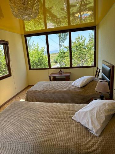 two beds in a room with two windows at Nor Takh in Khndzoresk