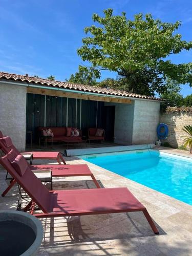 - une piscine avec 2 chaises longues à côté d'une maison dans l'établissement Le240b #4, à Saint-Mard