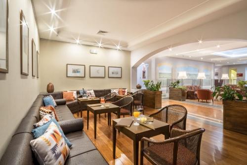 a living room with a couch and tables at Sina Maria Luigia in Parma