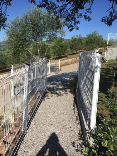 a metal fence with a gate on a road at Charmant T2 en rez de villa, neuf, tout équipé, indépendant avec jardin attenant in Afa