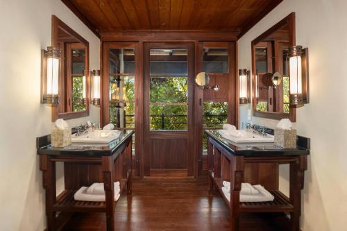 a bathroom with two sinks and two mirrors at JA Enchanted Island Resort Seychelles in Round Island