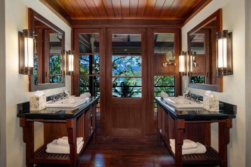 a bathroom with two sinks and two mirrors at JA Enchanted Island Resort Seychelles in Round Island