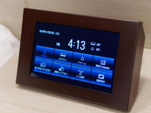 a digital alarm clock sitting on top of a table at Hotel Keihan Tsukiji Ginza Grande in Tokyo