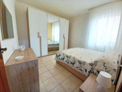 a bedroom with a bed and a table and a mirror at Le Rose Apartment in Ortona