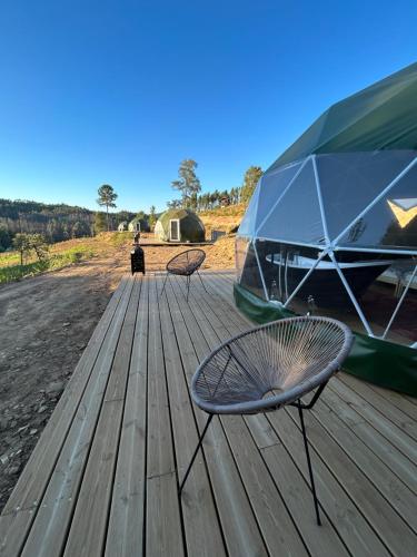 two chairs on a wooden deck with a tent at Quinta de São José dos Montes in Ferreira do Zêzere
