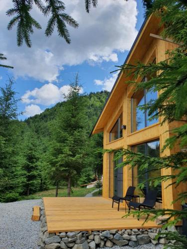 a log cabin with a deck and two chairs on it at La hambare in Colibiţa