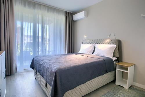 a bedroom with a bed and a large window at Anel apartment in St. St. Constantine and Helena