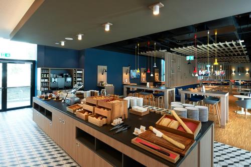 a large kitchen with a counter with a counter sidx sidx sidx at Holiday Inn Express & Suites - Basel - Allschwil by IHG in Basel