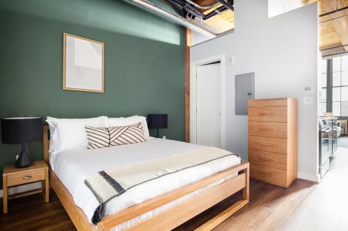 - une chambre avec un lit et un mur bleu dans l'établissement Bright Fort Point Studio w WD in Unit BOS-260, à Boston