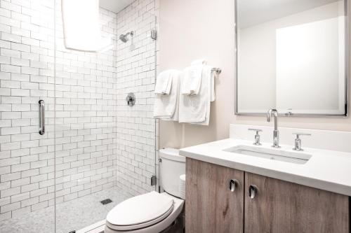 a white bathroom with a toilet and a sink at Bright Fort Point Studio w WD in Unit BOS-260 in Boston