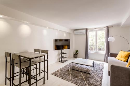 un salon avec un canapé et une table dans l'établissement Design 1 BDR with AC, à Paris