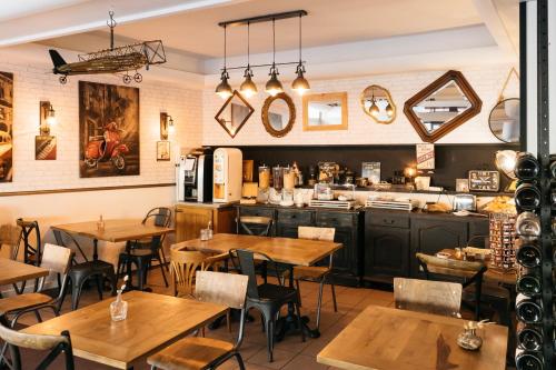 ein Restaurant mit Holztischen und einer Küche in der Unterkunft Hôtel Restaurant La Voile - Le Dock'er in Locmariaquer