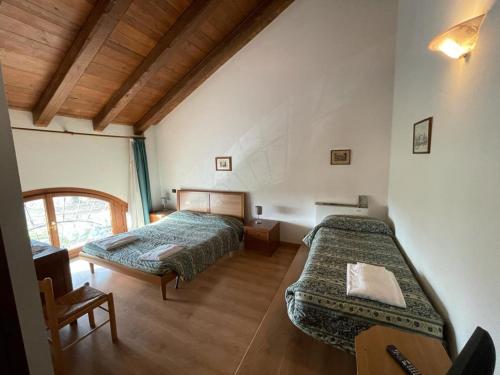 a bedroom with two beds and a chair in it at Agriturismo Rechsteiner in Ponte di Piave