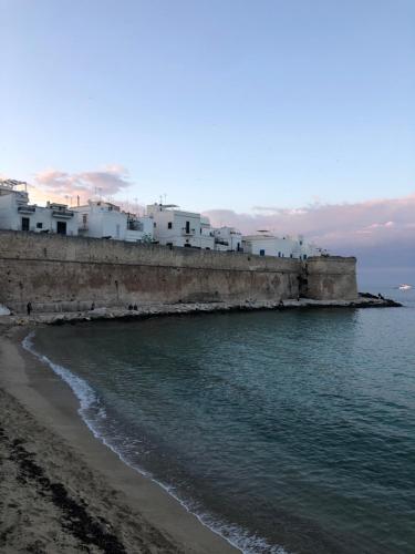 a group of white buildings sitting on the beach at DIMORA ELIVA in Monopoli