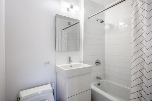 a white bathroom with a sink and a toilet at Midtown 1BR w Pool Gym Parking nr Times Sq NYC-378 in New York
