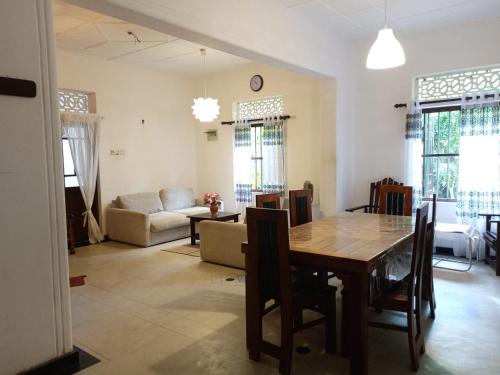 een woonkamer met een tafel en een bank bij Shine Breeze villa in Weligama