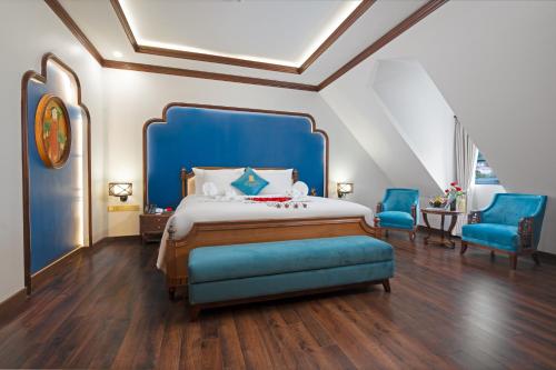 a bedroom with a blue bed and two blue chairs at Grand Fleuve Boutique in Ha Long