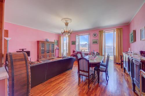 une cuisine avec des murs roses, une table et des chaises dans l'établissement Il Porticciolo Stresa Stunning Lake View - Happy Rentals, à Stresa