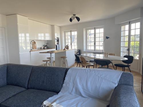 Il comprend un salon avec un canapé bleu et une cuisine. dans l'établissement Villa Ster et Mer, à Plobannalec-Lesconil