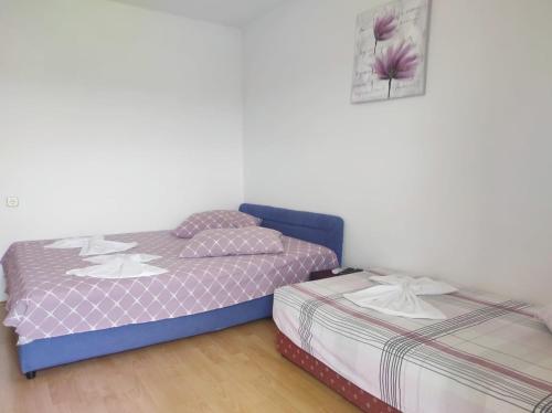 two beds sitting next to each other in a room at Apartments Kata in Neum
